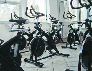 Healthy lifestyle concept. Lot of exercise bicycle in empty hall spinning class.