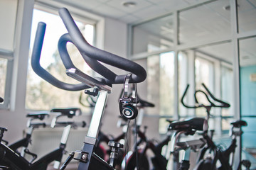 Obraz premium Headphones hanging on a stationary bike at spinning class