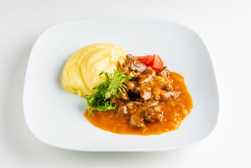 meat with mashed potato on the white plate