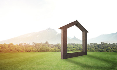 Conceptual background image of concrete home sign on green grass