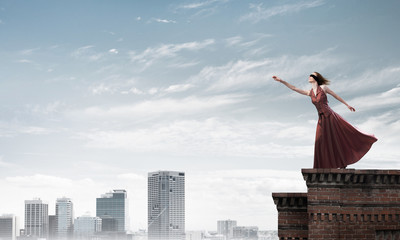 Blind woman in long red dress at top of building. Mixed media