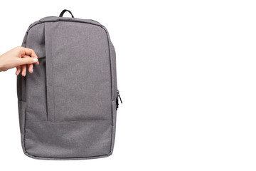 Hand with gray textile school bag, city street backpack