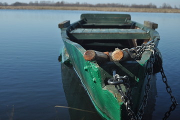 Rowing boat moored to the shore. Spring on the river. Floating.