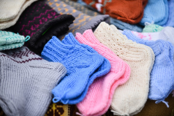 A row of multicolored hand-knitted baby socks