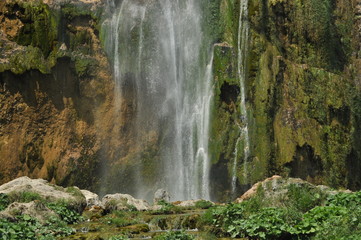 High waterfall, the water flowing from the rocks into the lake. National Park Plitvice Lakes. Tourism in Croatia.