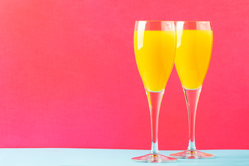 Festive alcohol cocktail mimosa with orange juice and cold dry champagne or sparkling wine in...