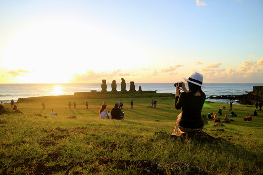 Female Tourist Taking Photos of the Famous Sunset Scene at Ahu Tahai, Easter Island, Chile 
