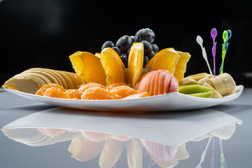 Naklejka na ściany i meble Mixed fruit in white plate isolated on white background - Healthy food style