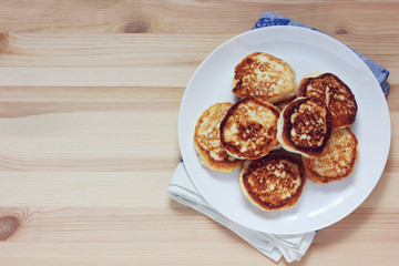 plate with cheesecakes or pancakes on the table, top view.