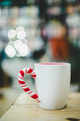 Steaming cup of thee on a wooden table, christmas time, blurry background