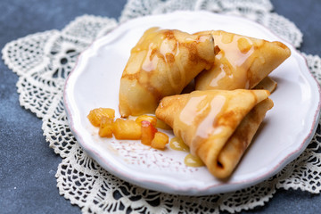 Crepes in the form of triangles stuffed with apples.