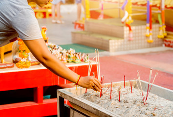 Symbols of Buddhism. Burning incense sticks. South-Eastern Asia. Details of buddhist temple in Thailand.