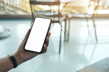 Mockup image of a woman's hand holding black mobile phone with blank desktop screen