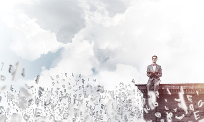 Obraz premium Young businessman or student studying the science and symbols fly around