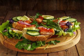 Smoked salmon sandwich with on wooden table. Top view