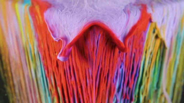 Multicolored ink paint slowly flows from the cube underwater
