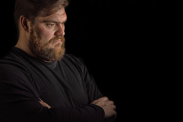 Close-up face profile portrait strong serious brutal bearded man on black. Confident and dramatic concept