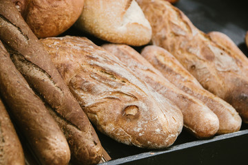 different fresh bread on the shelves in bakery. Selective focus