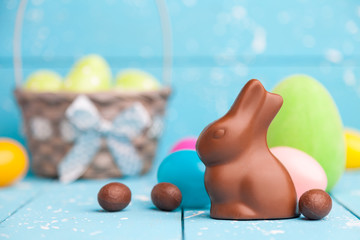 Chocolate Easter bunny, eggs and sweets on rustic background