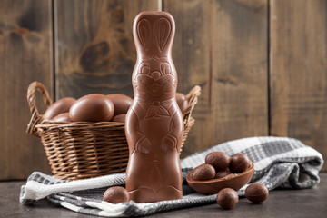 Chocolate Easter bunny, eggs and sweets on rustic background