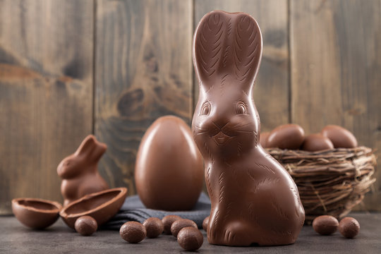 Chocolate Easter bunny, eggs and sweets on rustic background