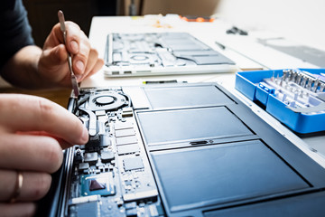 Cleaning a laptop at a professional service. Person performs regular service and changes thermal...