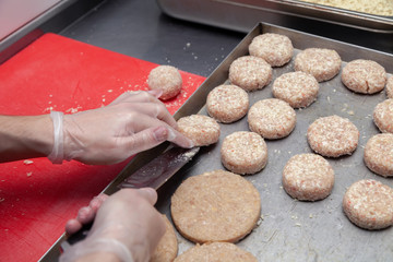 Chef hands in gloves creating forming chicken cutlets with knife for burgers. Ingredients. Concept restaurant business, fast food, preparation for cooking, gastronomy, patty, meatballs, menu