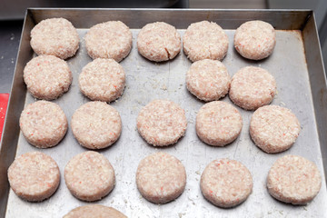 Closeup preparation of chicken cutlets for burgers. Bread crumbs and butter on the metal kitchen table. Ingredients. Concept restaurant business, fast food, tasty food, gastronomy, cooking, menu