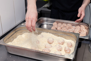Chef hands creating, forming, breading chicken cutlet with knife on professional restaurant kitchen. Concept fast food business, preparation for cooking, menu, gastronomy, burgers, patty, meatballs