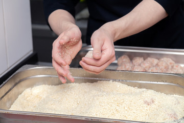 Chef hands creating, forming, breading chicken cutlet with knife on professional restaurant kitchen. Concept fast food business, preparation for cooking, menu, gastronomy, burgers, patty, meatballs