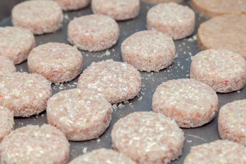 Closeup preparation of chicken cutlets for burgers. Bread crumbs and butter on the metal kitchen table. Ingredients. Concept restaurant business, fast food, tasty food, gastronomy, cooking, menu