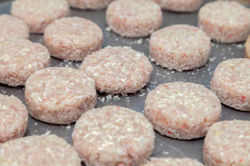 Closeup preparation of chicken cutlets for burgers. Bread crumbs and butter on the metal kitchen table. Ingredients. Concept restaurant business, fast food, tasty food, gastronomy, cooking, menu