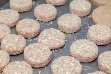 Closeup preparation of chicken cutlets for burgers. Bread crumbs and butter on the metal kitchen table. Ingredients. Concept restaurant business, fast food, tasty food, gastronomy, cooking, menu