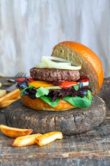 Venison burger in brioche bun with peppery leaf salad, onion and roast peppers