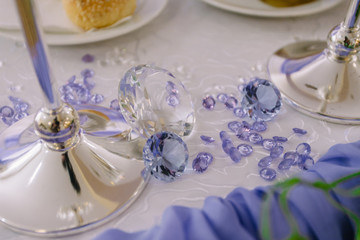 Obraz na płótnie Canvas Diamond (small purple jewel) stones heap over mirror glass table, crystal stones, shiny gold and silver jewelery on a table