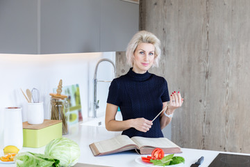 young blond woman cooking in modern kitchen