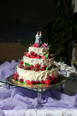 Naked wedding cake decorated with berries and flowers