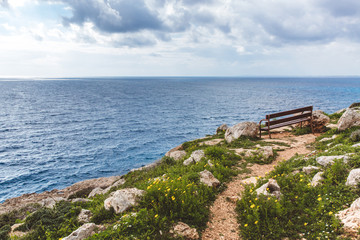Fototapeta na wymiar Bench stands on the seashore. Beautiful valley by the sea. Seascape in Cyprus Ayia Napa