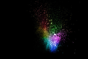 Launched colorful powder on black background.Color powder explosion.Colorful dust splashing.