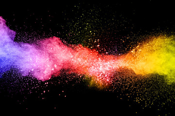 Launched colorful powder on black background.Color powder explosion.Colorful dust splashing.