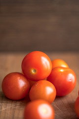 Fresh tomatoes on wooden table over bokeh background white knife beside