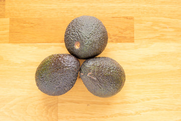 avocado on a wodden bright table standing up focus on top