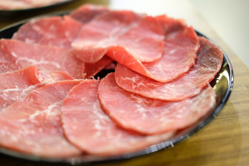 Raw sliced meat on the black dish