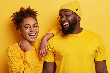 Photo of delighted cheerful young Afro American woman and man smile broadly, satisfied with good...