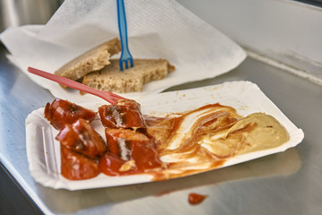 sausages on a paper plate with mustard ketchup and bread