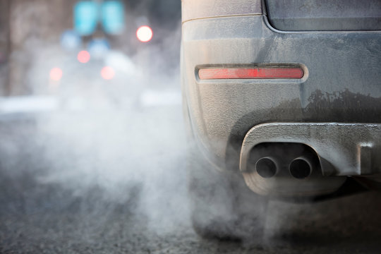 Car exhaust pipe, which comes out strongly exhaust gases in Finland. It is winter and the car is very dirty.