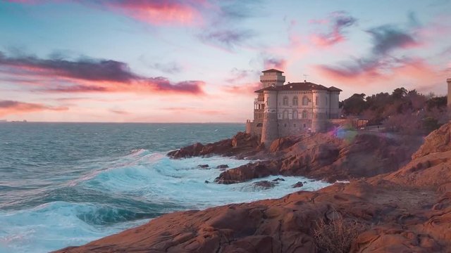 Castello antico sull'Oceano tempestoso con scogliera al tramonto. Slow motion.