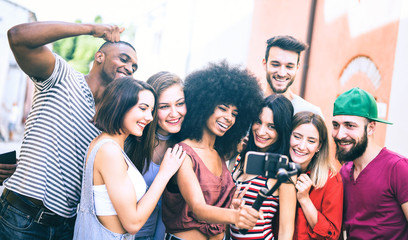 Multiracial friends taking video selfie with mobile phone on stabilized gimbal - Young people...