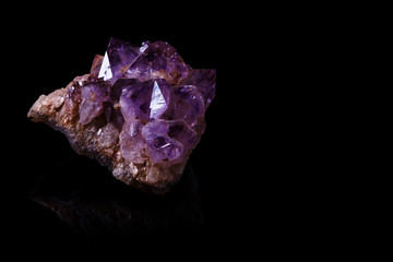 Large Chunk of Amethyst Crystals on a Reflective Black Surface