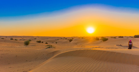 Fototapeta na wymiar Jeep safari at sunset over sand dunes in Dubai Desert Conservation Reserve, United Arab Emirates. Copy space for text.